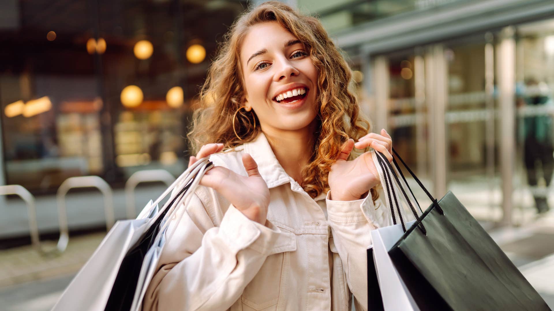 smiling woman impulse buying with shopping bags