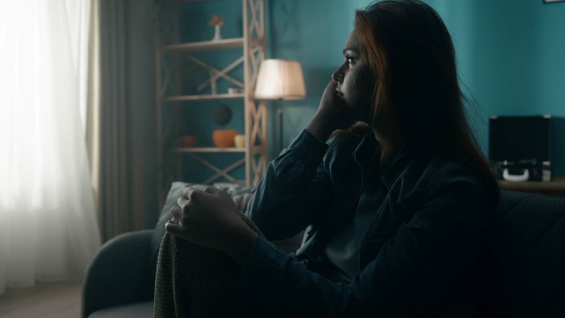 exhausted woman sitting in the dark at home