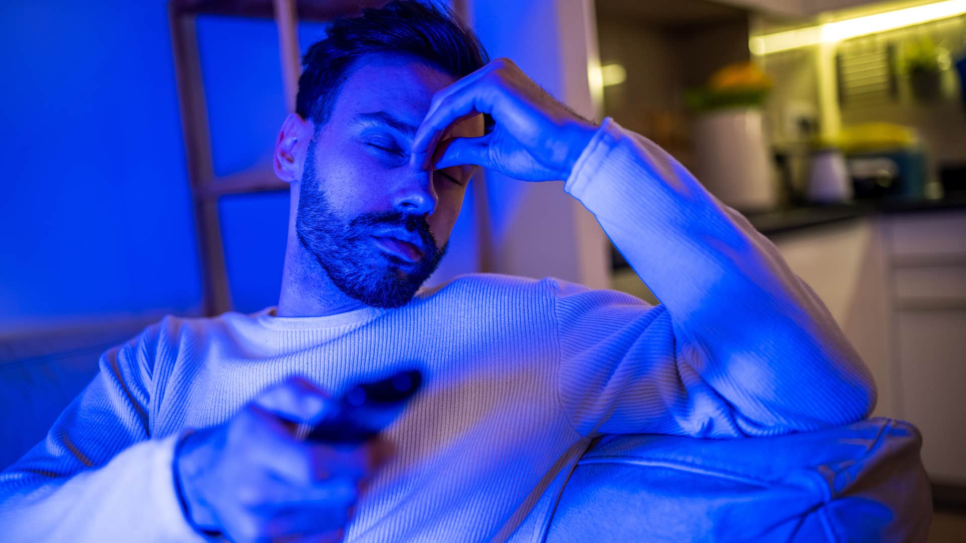 man sitting in dark watching tv avoiding silence