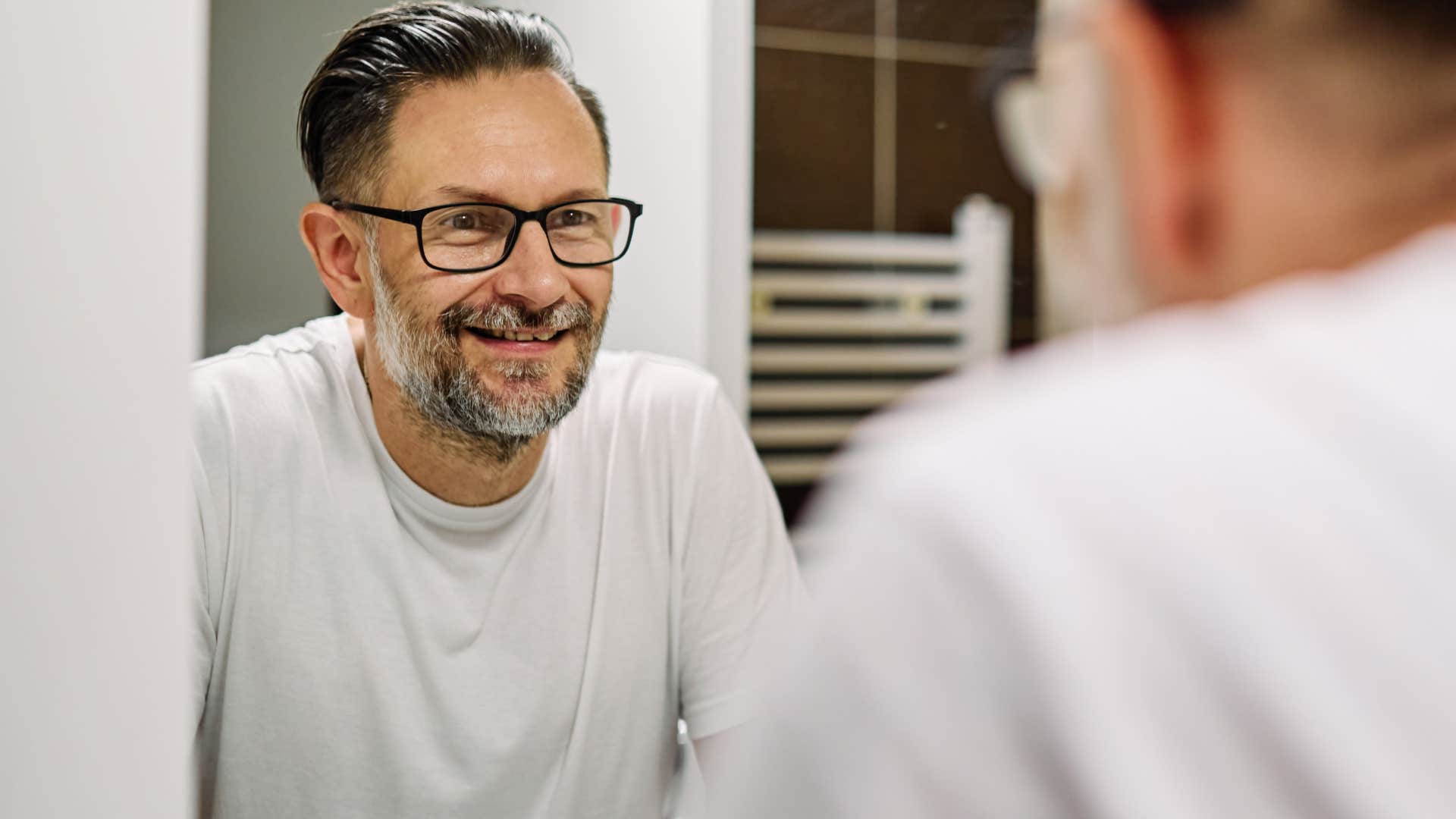 Compassionate man looking at himself in the mirror.