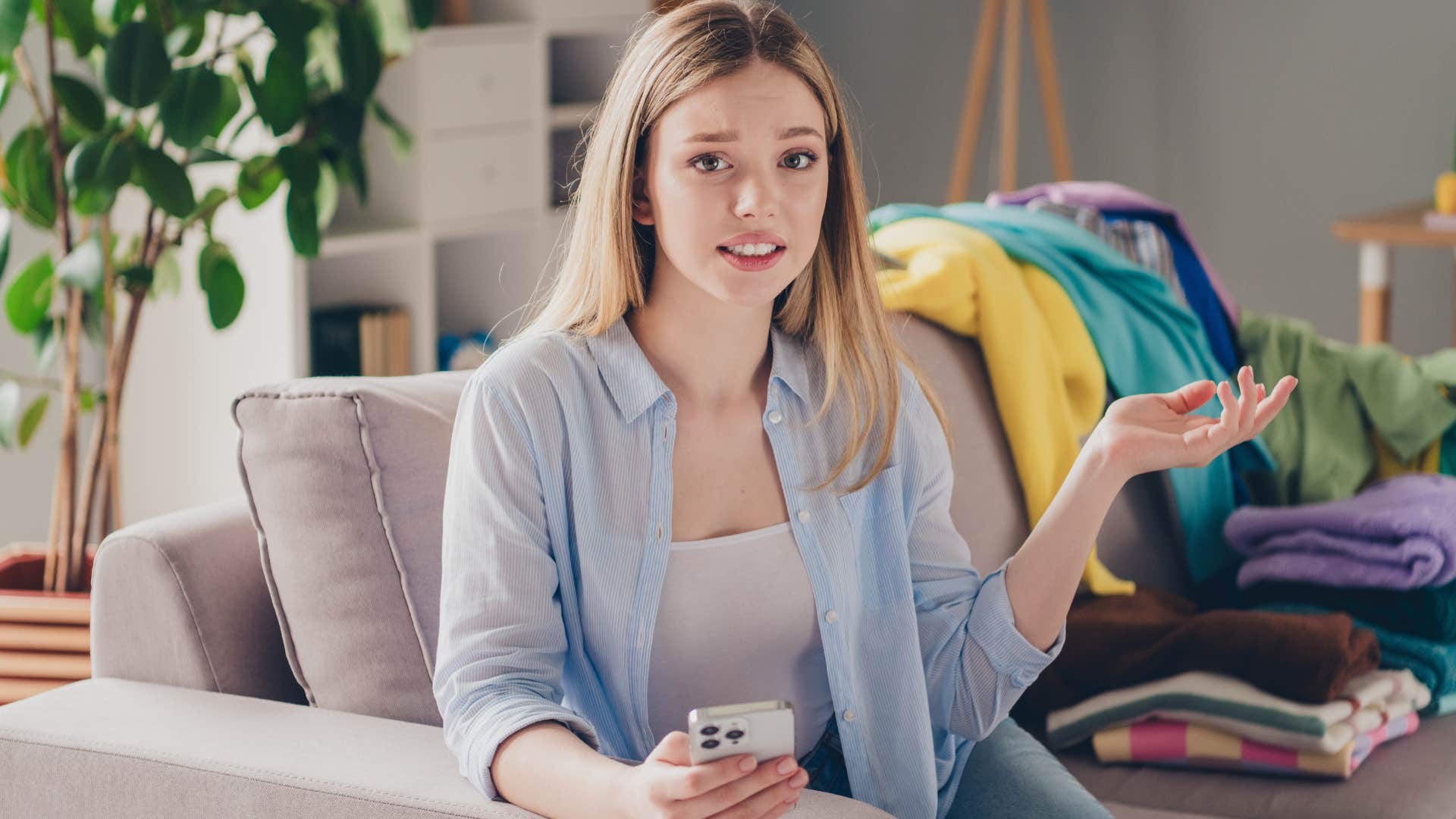 Woman who's okay with imperfection sitting in a messy house.