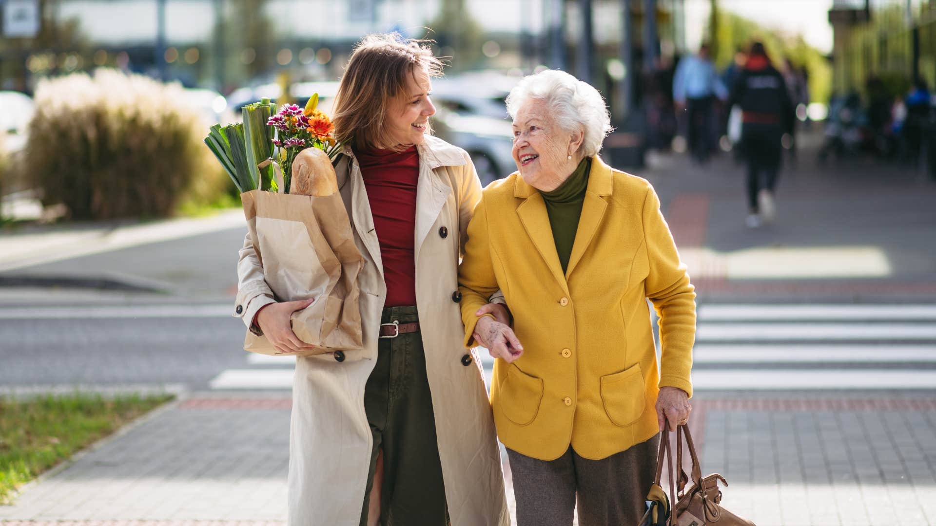 conscientious woman helping elderly lady to her car