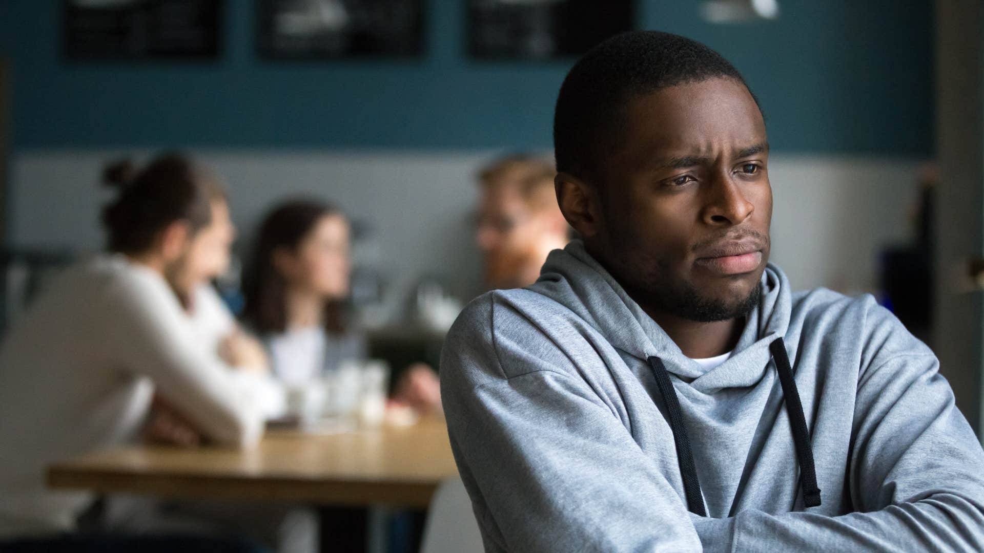 man being excluded from conversations with group of people