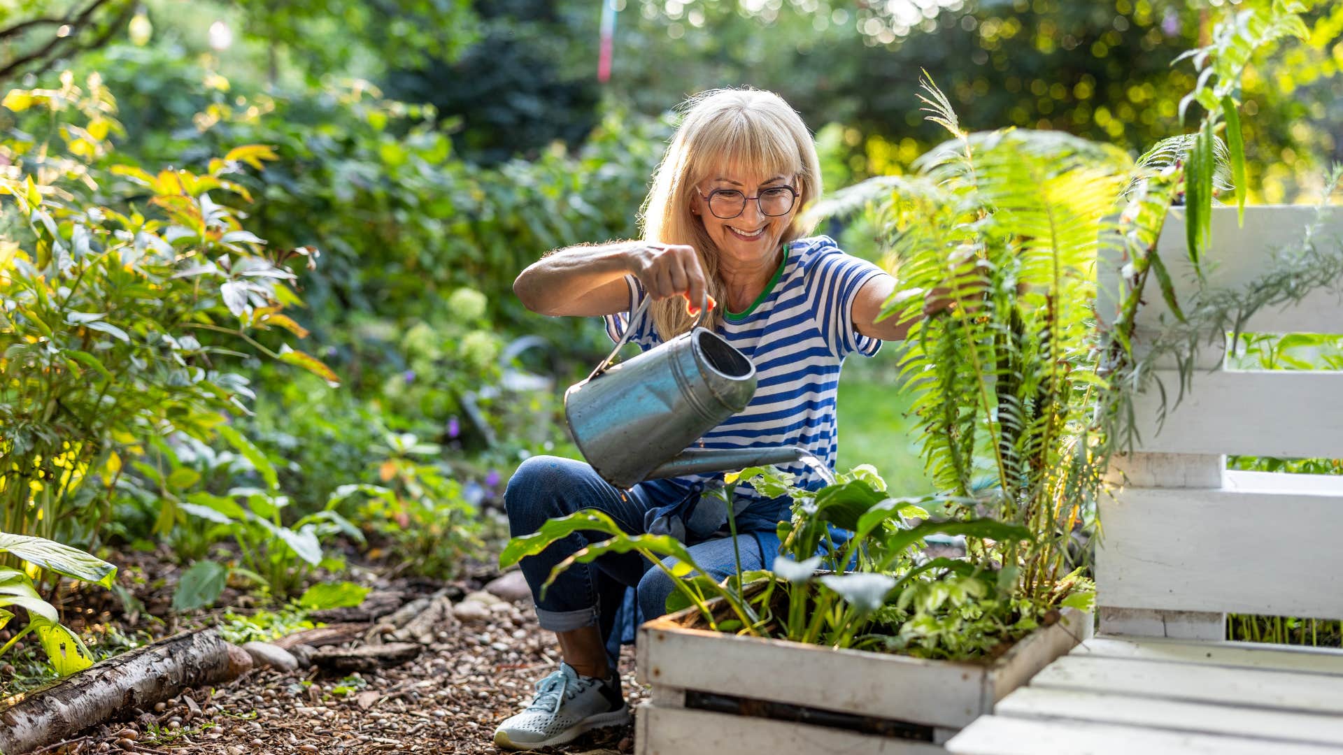 Happy person waters garden showing importance of health after divorce
