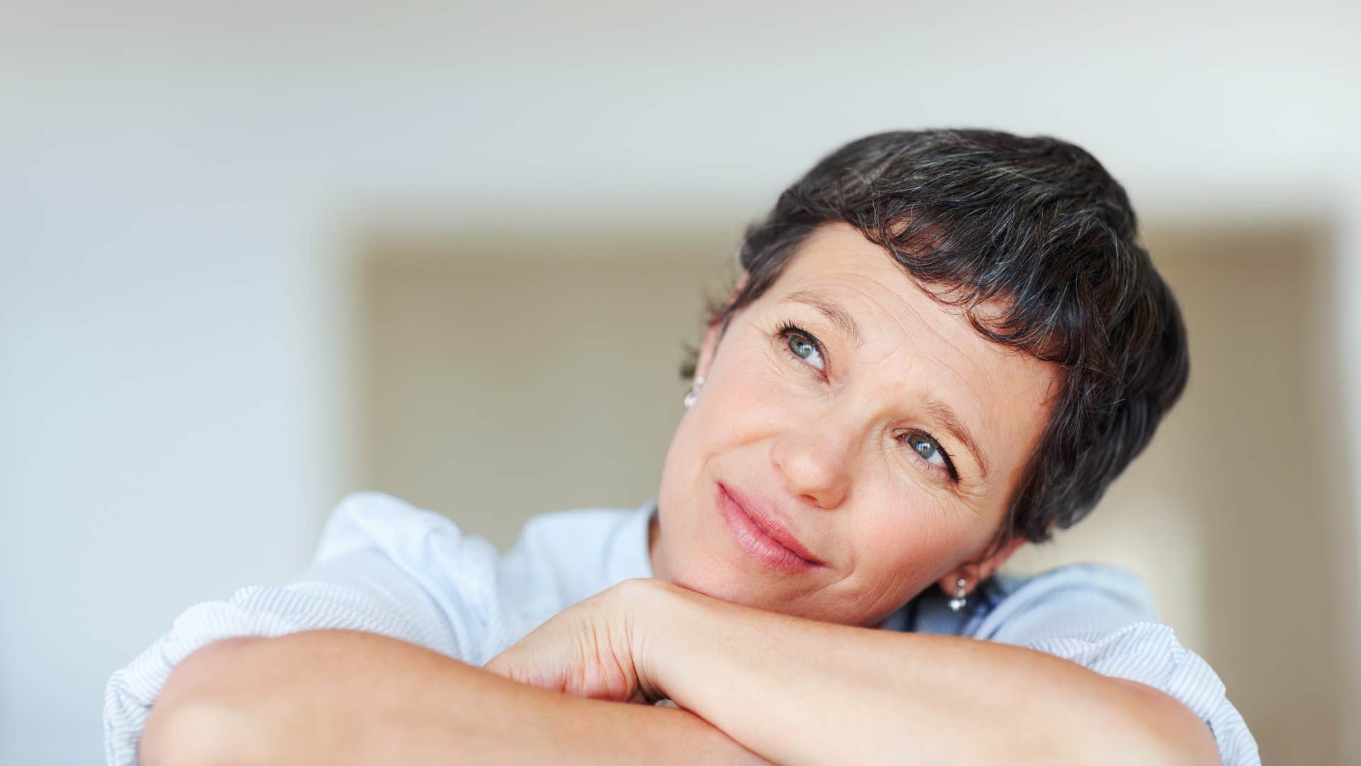 Introspective person rests head on arms showing importance of focus on now after divorce