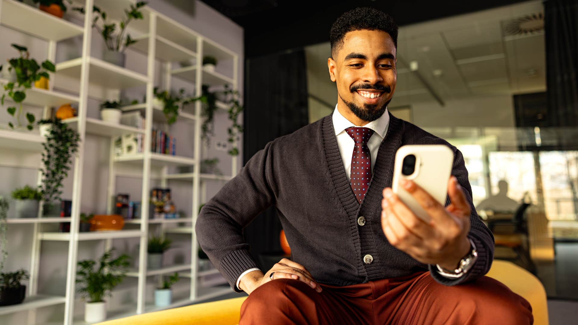 internally motivated man smiling looking at his phone