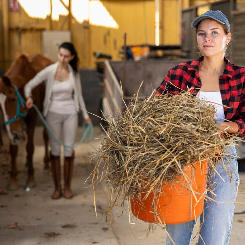 Woman with hay feeding horses and making it her personality