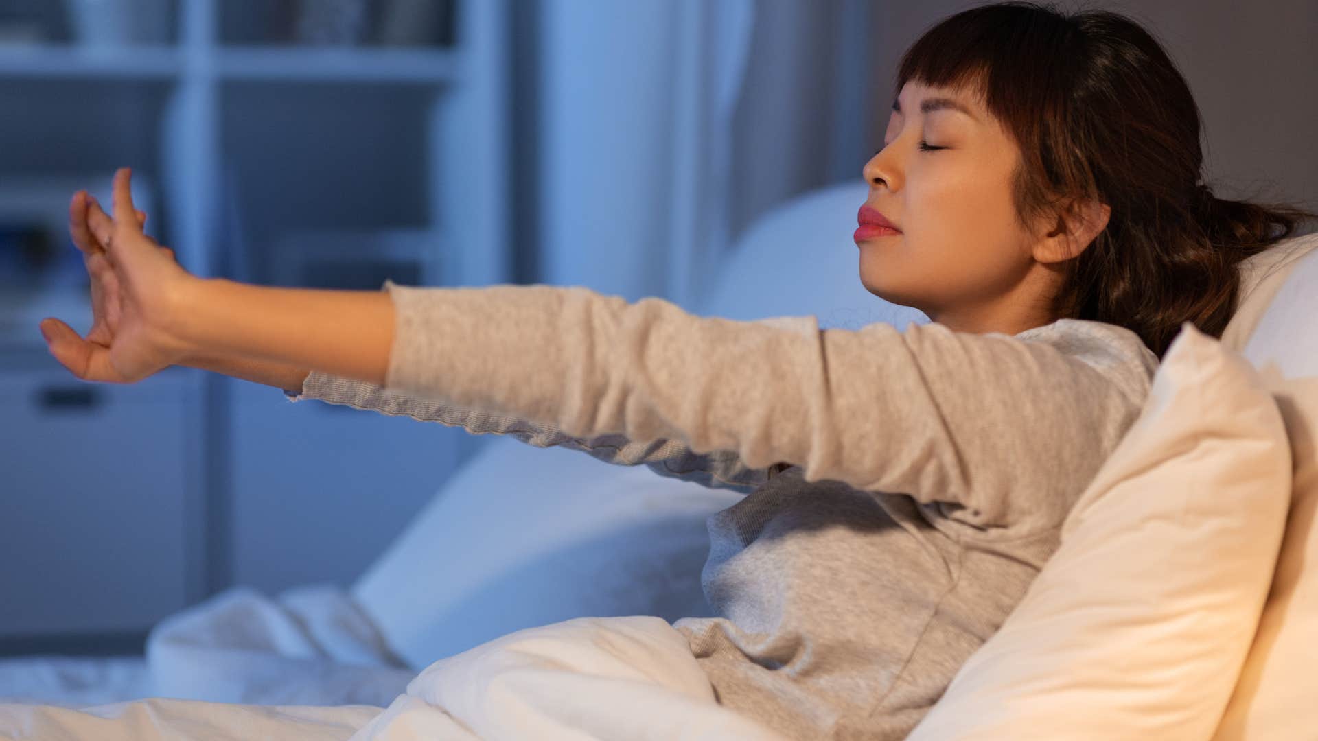 Disciplined woman stretching in bed.