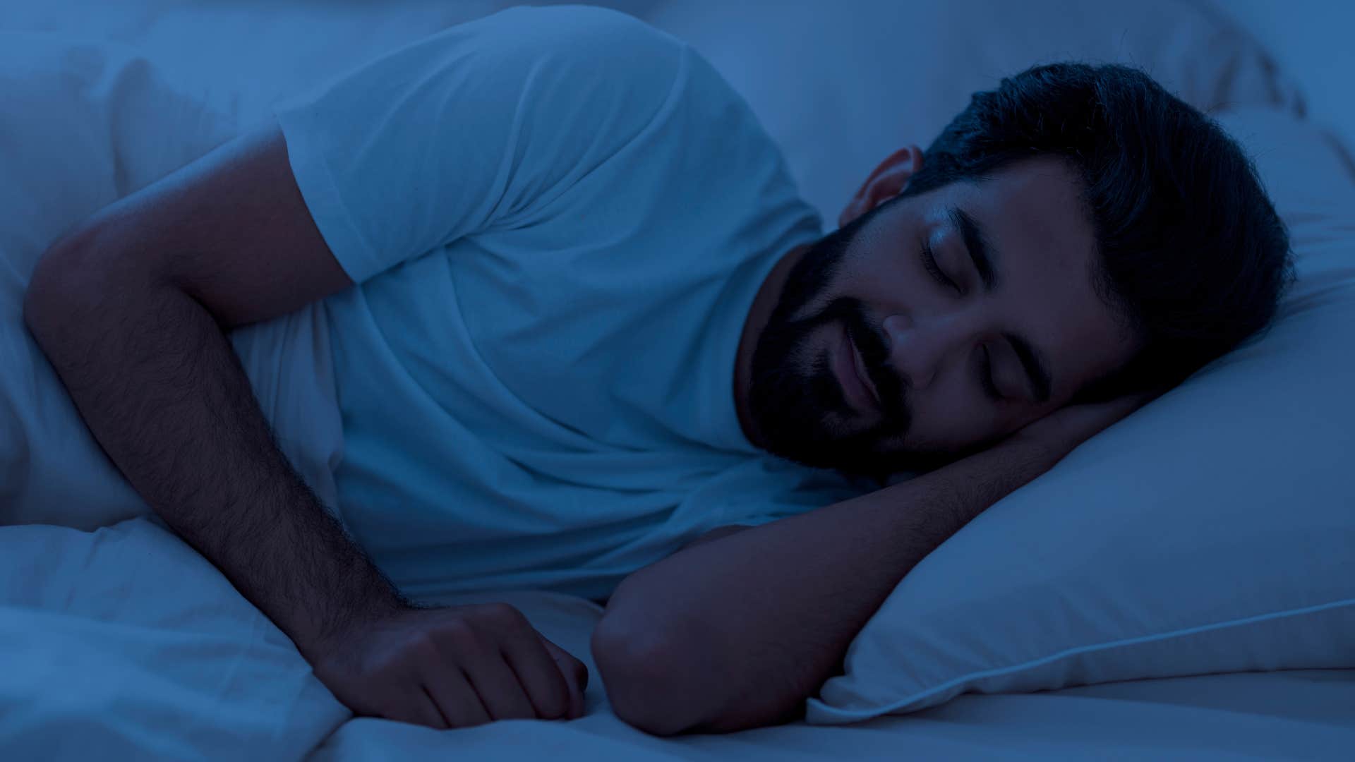 Man who dislikes unpredictability sleeping in a dark room.