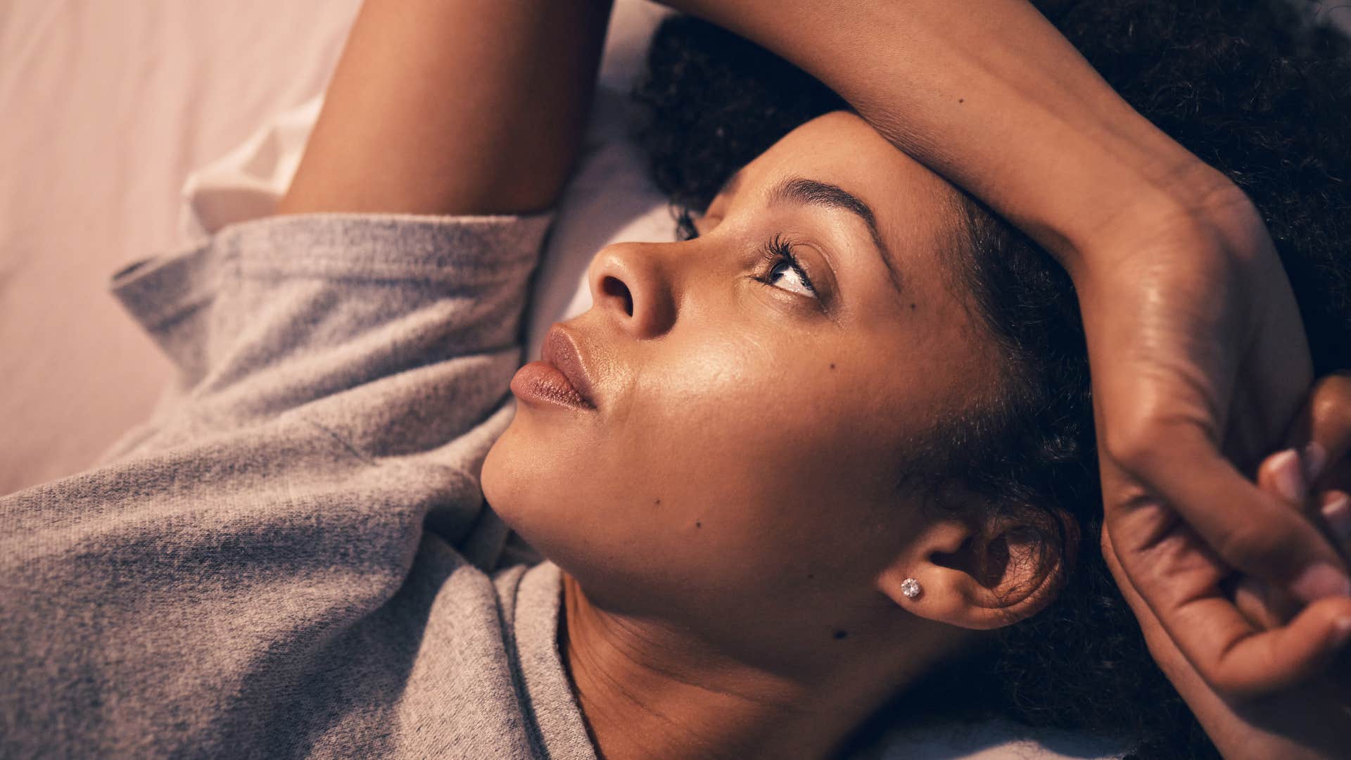 Woman who feels things deeply lying in bed alone.
