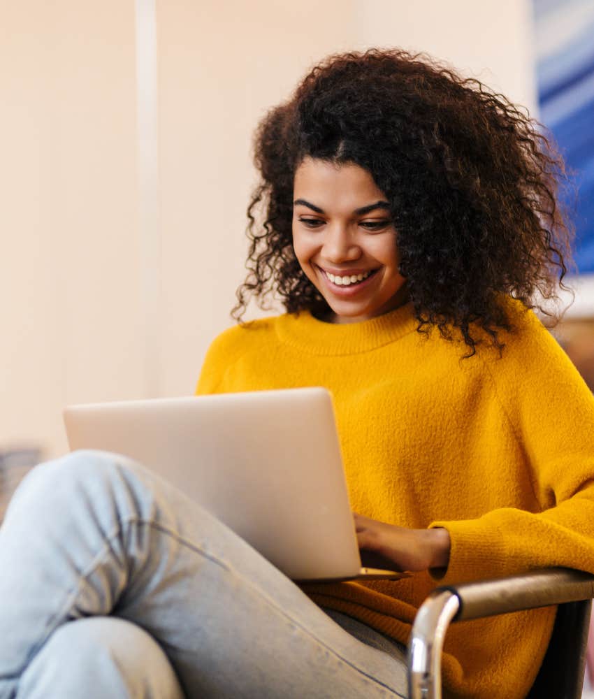 Focused person in sweater works on laptop showing conscientious personality