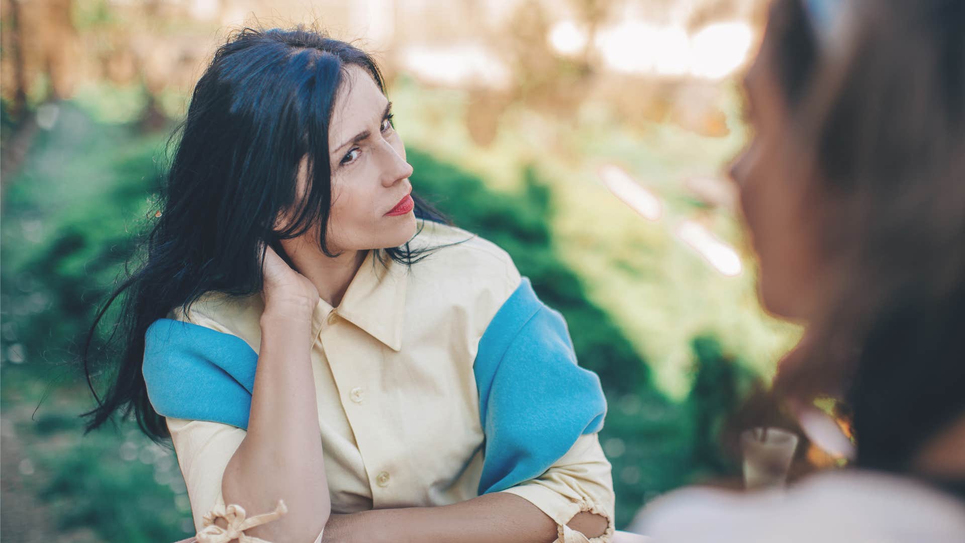 sly woman talking to friend telling them i heard something about you