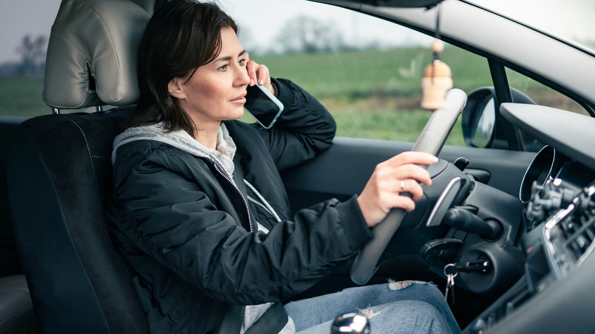 Introverted woman driving and talking on the phone.