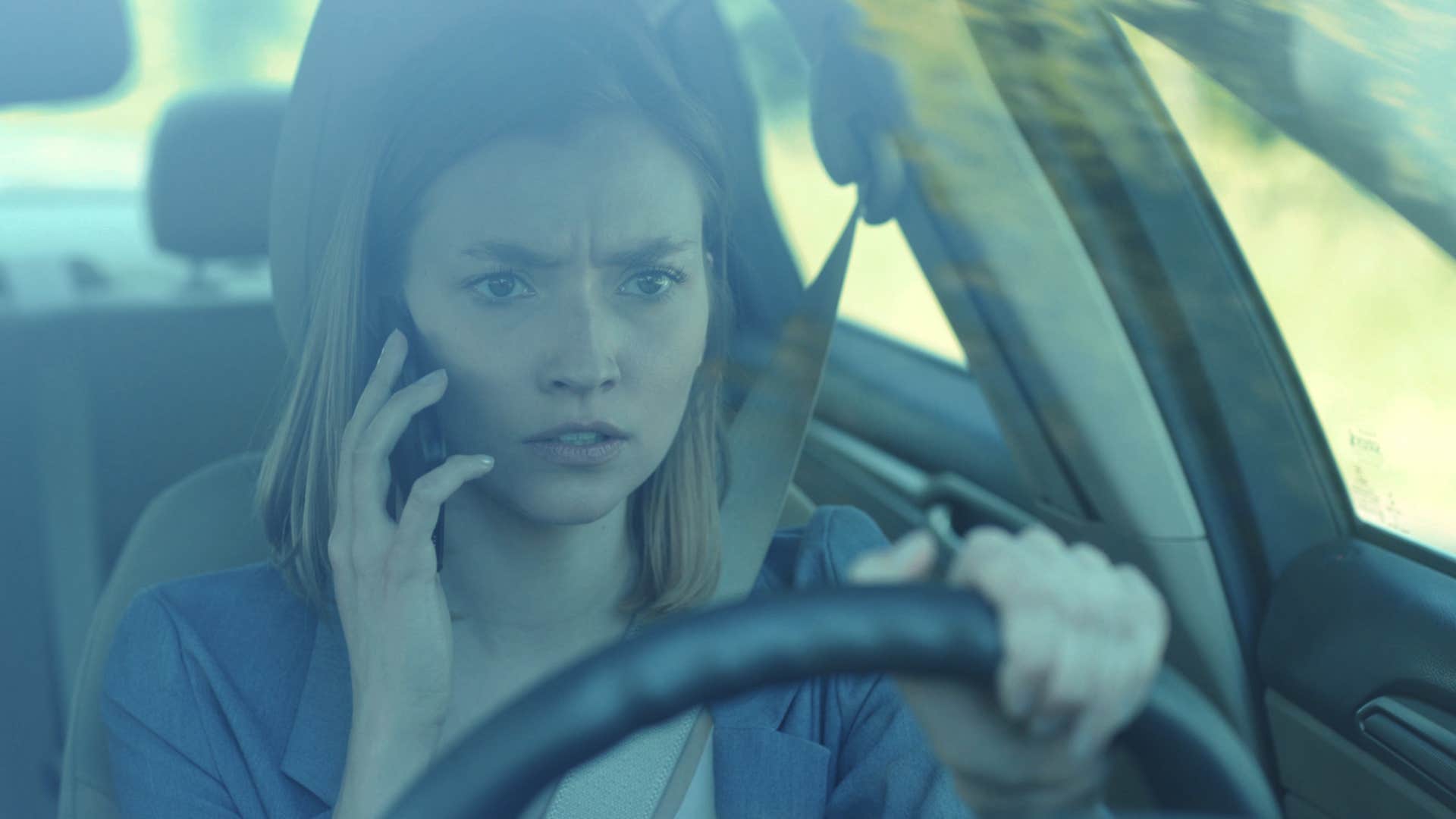 Woman who's an overthinker talking on her phone in a car.