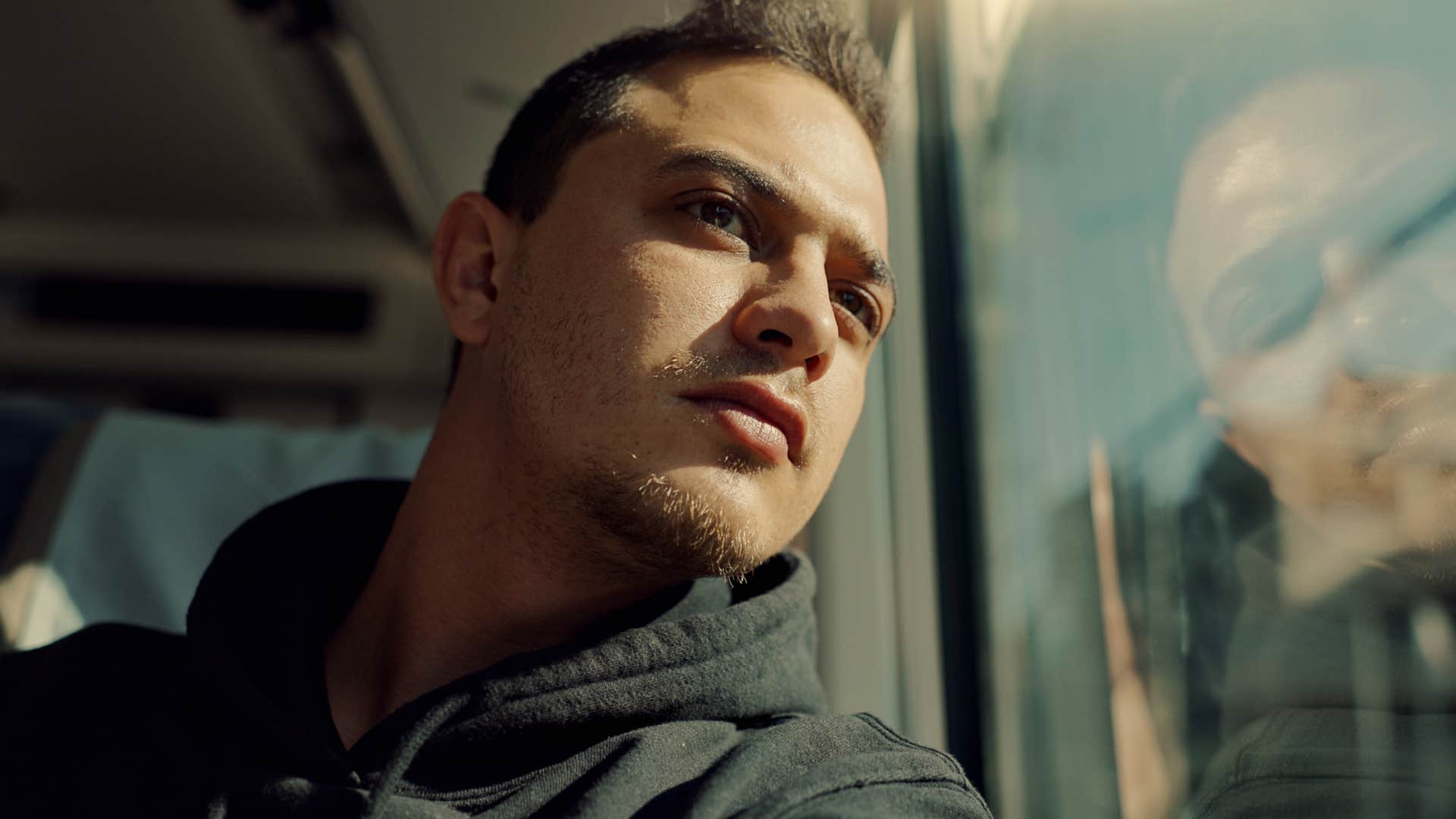 man who's incredibly reflective sitting on a train at night