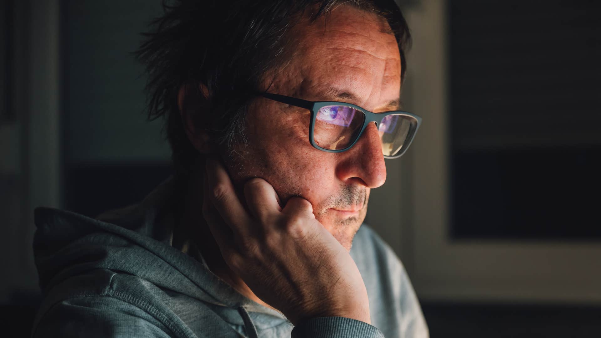 man who's a perfectionist looking at a screen at night