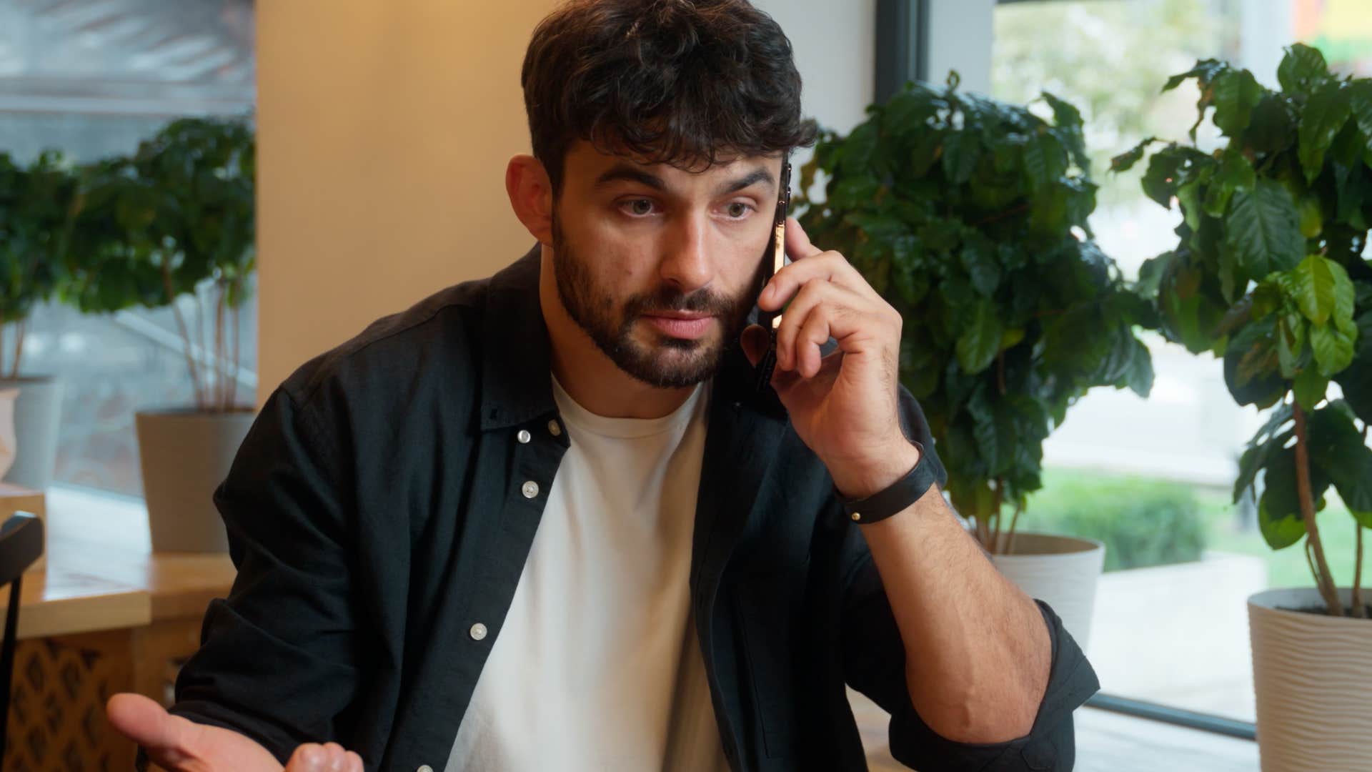 Man saying "What do you mean by that?" on the phone.