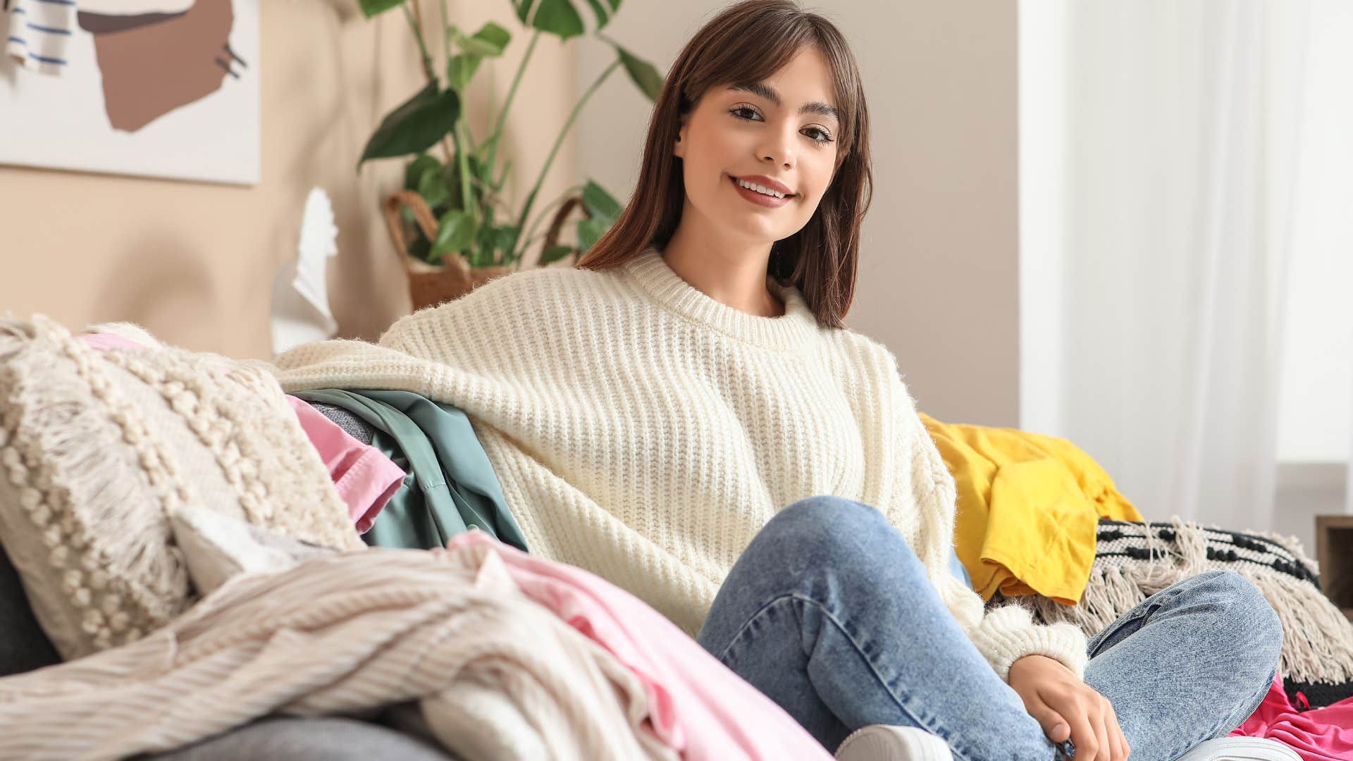 woman who doesn't over-romanticize cleanliness sitting with a clothing pile