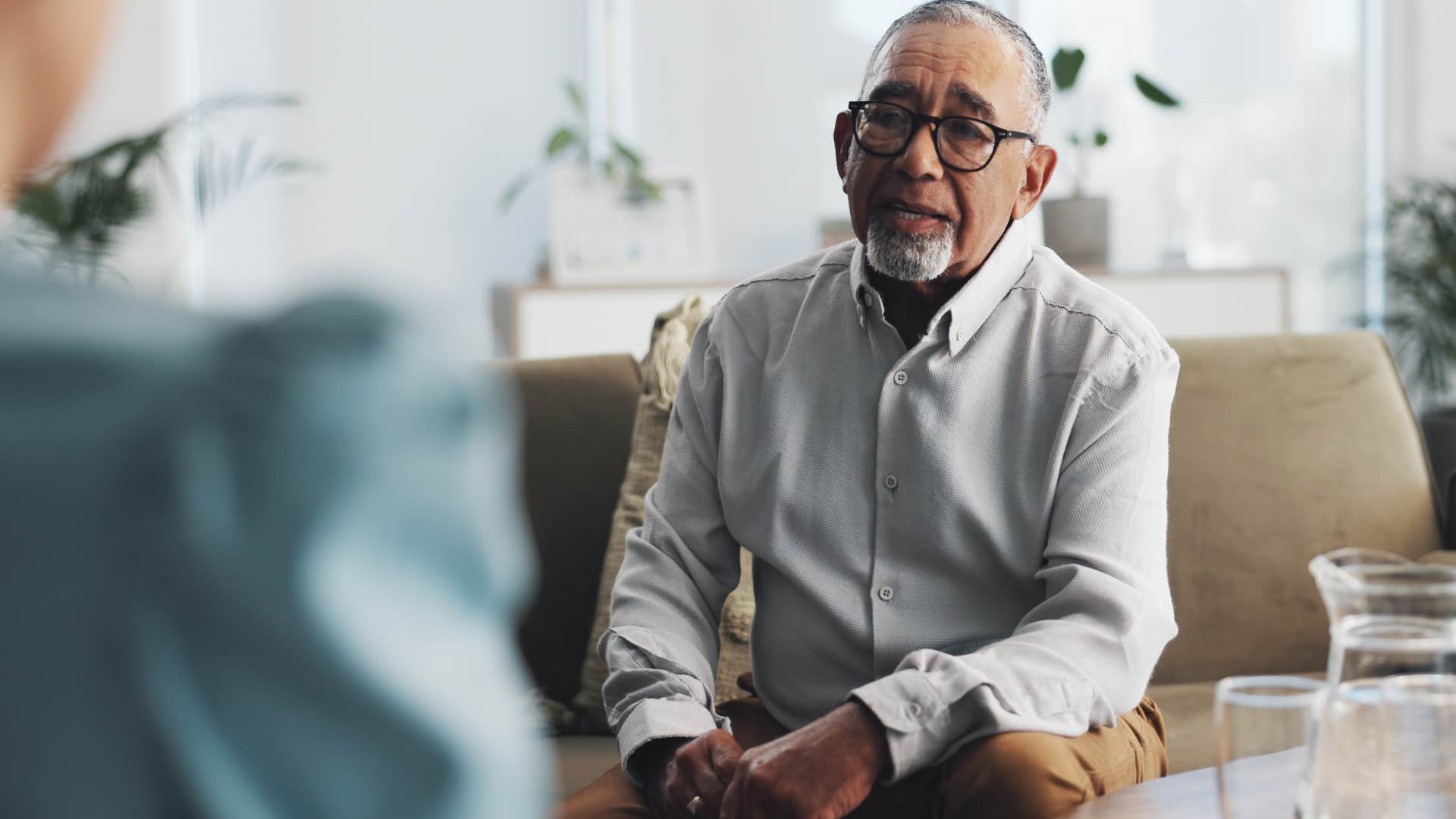 man feeling anxious around new people talking with therapist