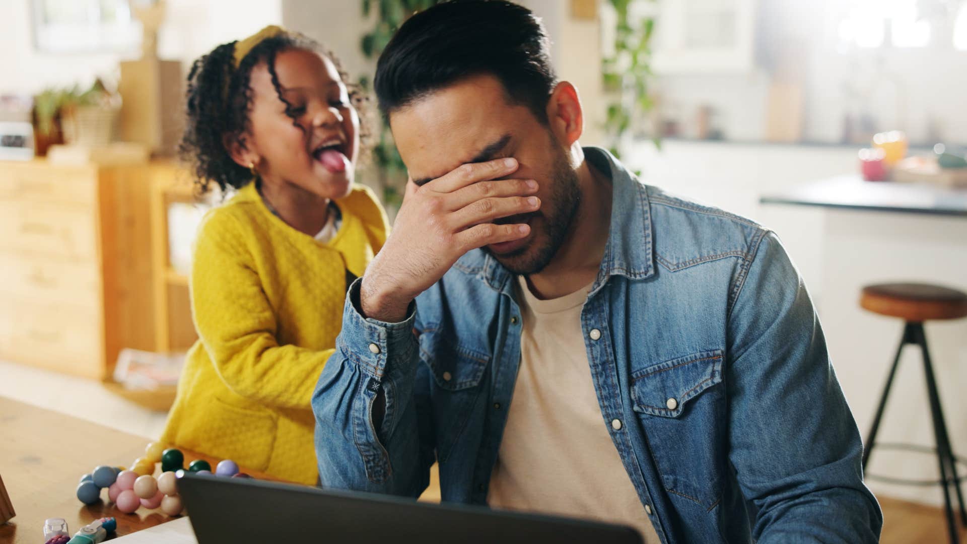stressed man who's easily overstimulating holding his head