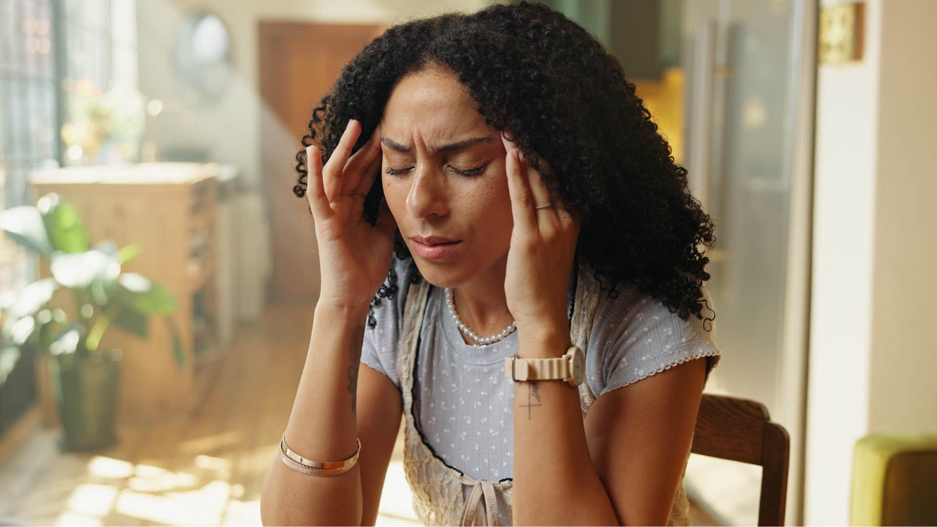 woman who's an overthinker sitting at home feeling stressed