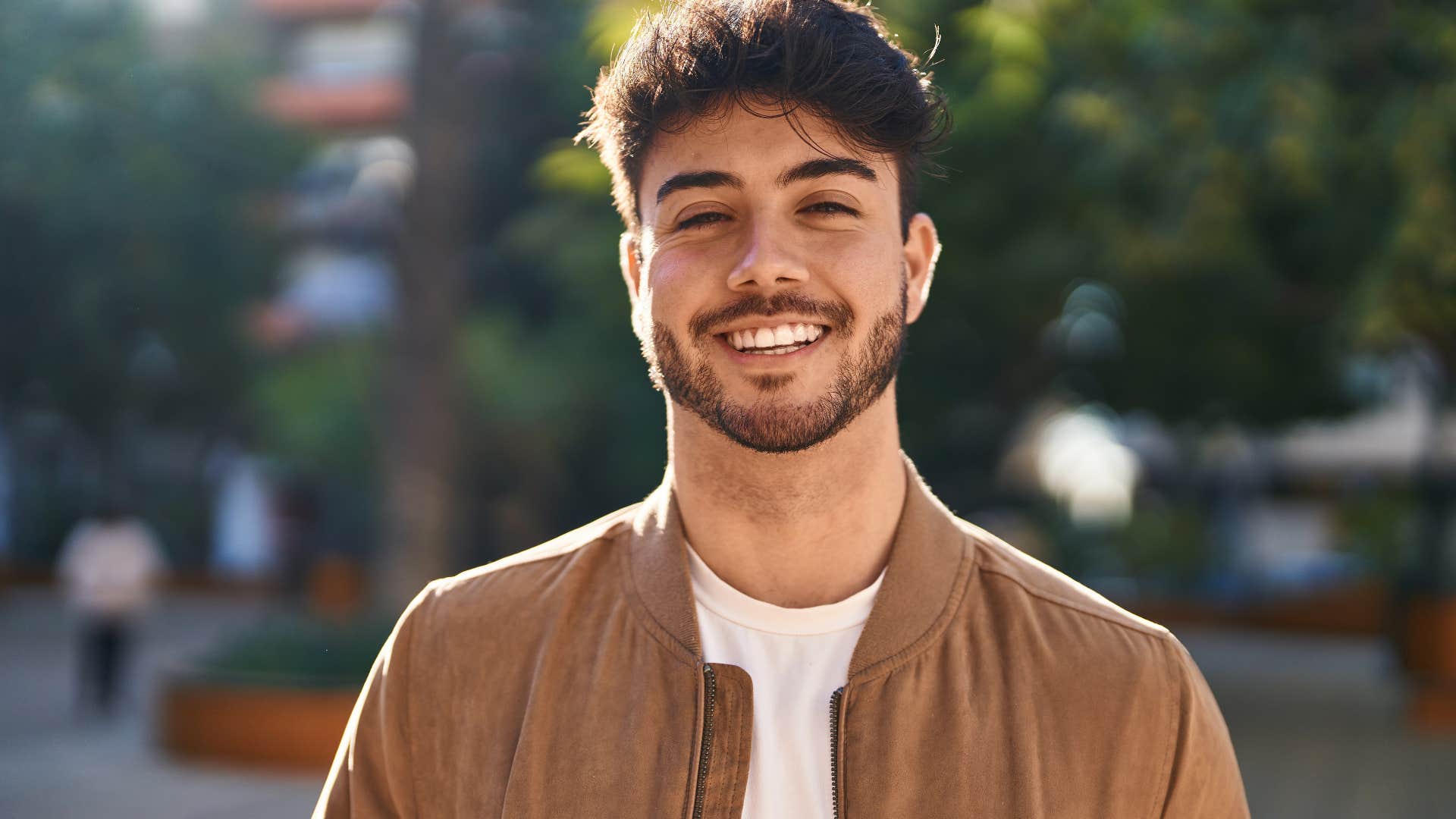 happy young man smiling standing on the street