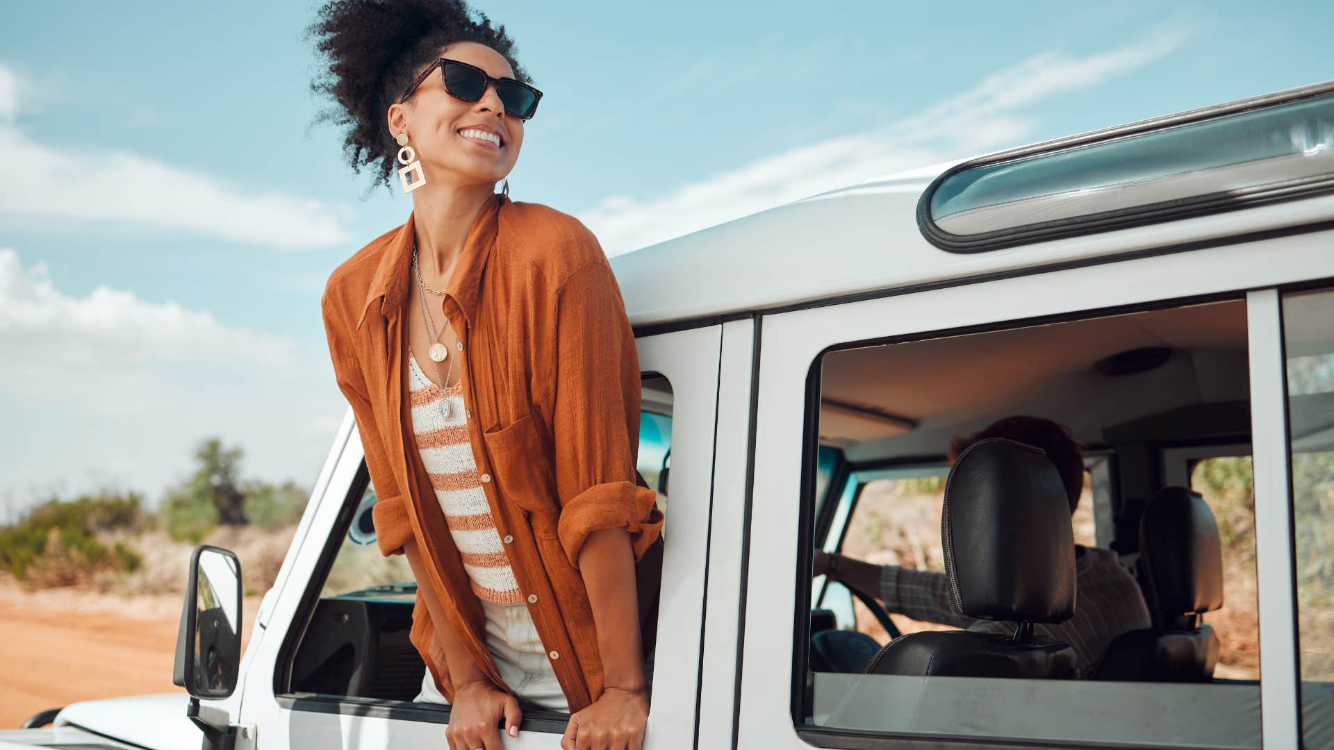 woman having fun hanging out of car window
