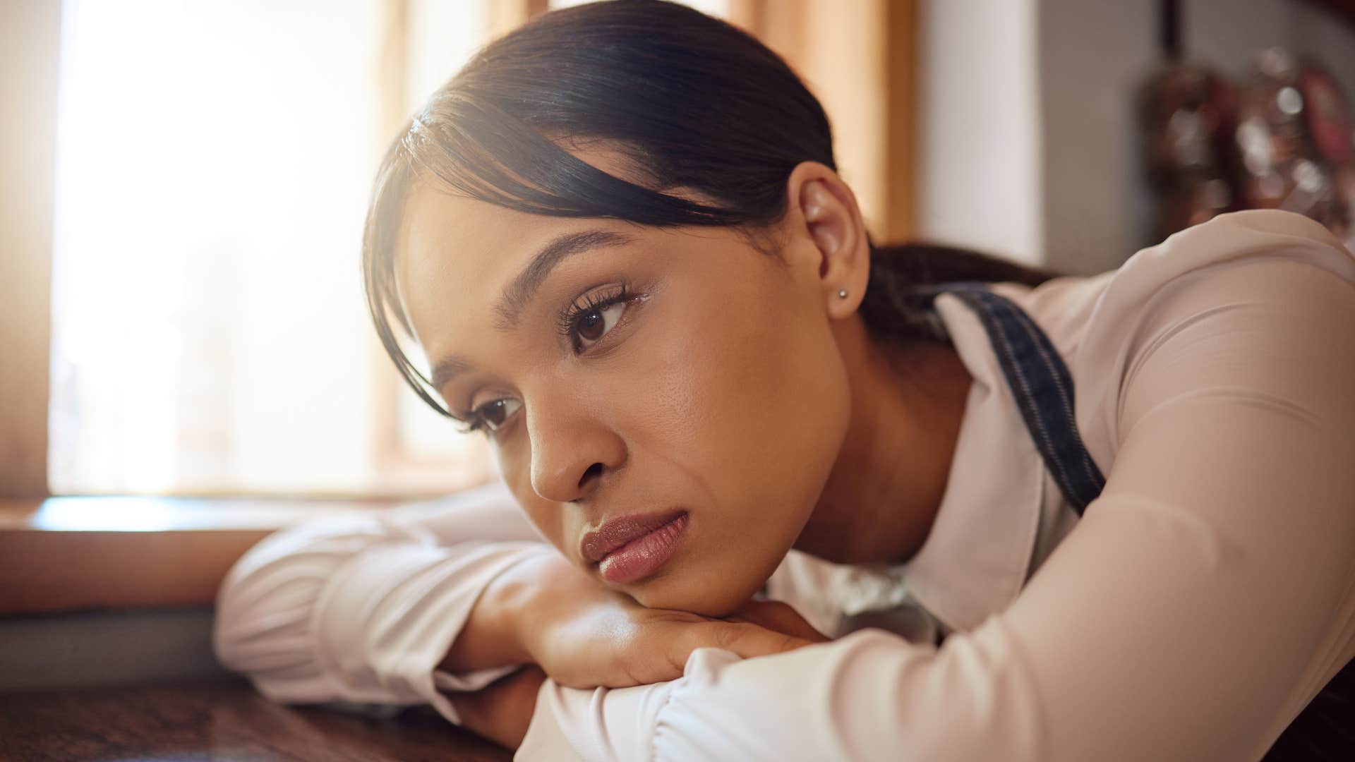 Sad person rests head on arms showing memories tie self-worth to relationship