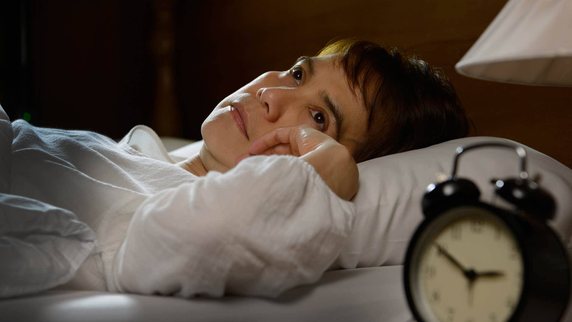 lonely woman lying awake in bed