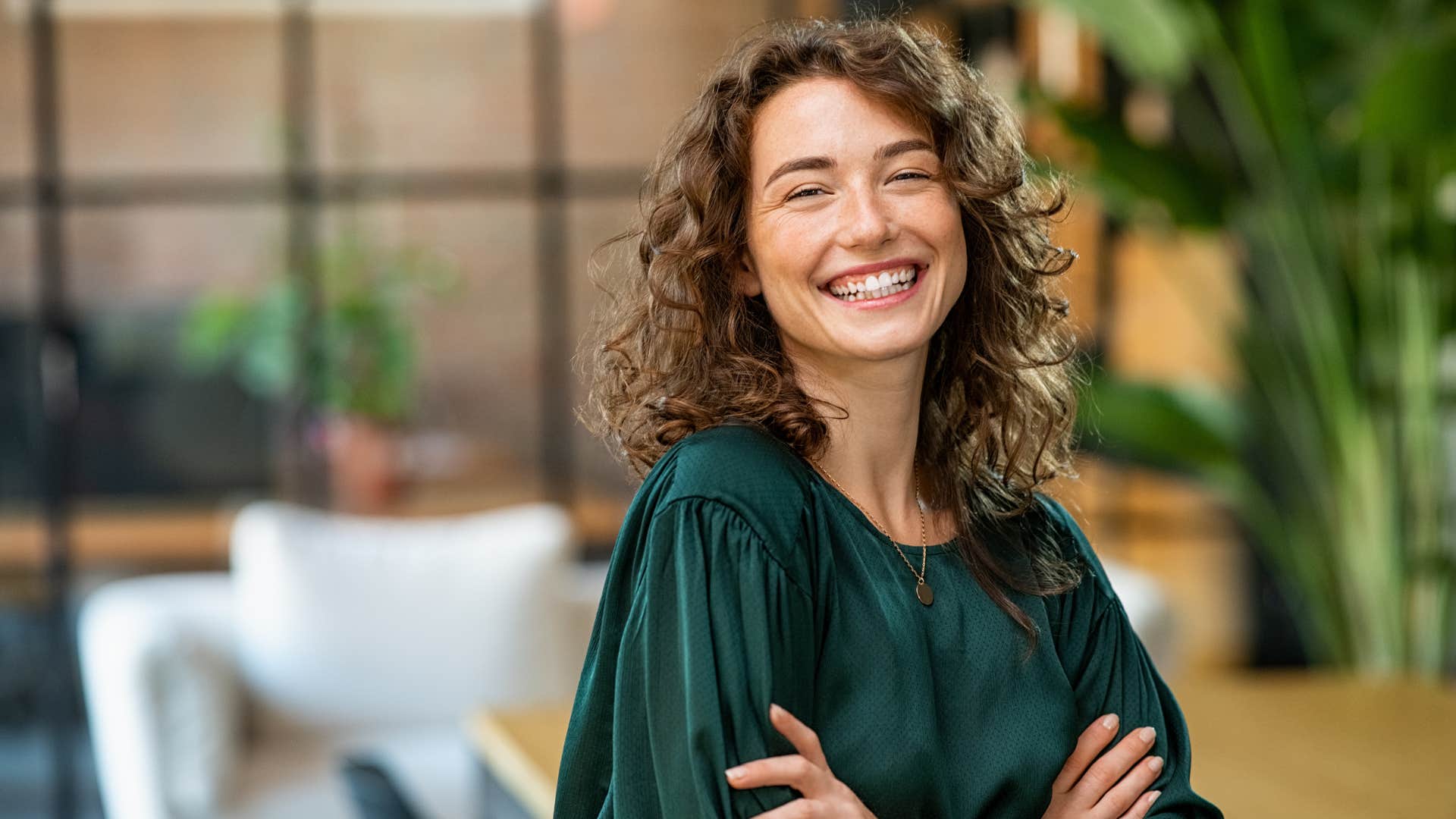 woman in green shirt crossing arms confidently as she thinks nothing bad will happen