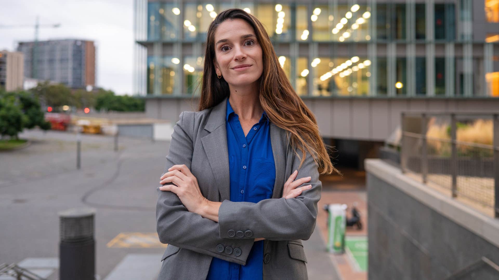 woman in dark blue shirt crossing arms as she thinks well that'll never happen to me