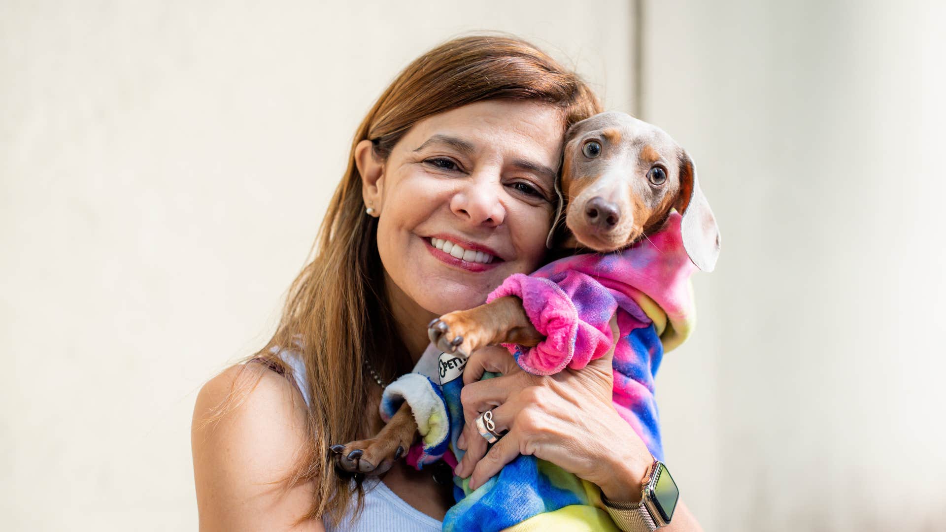 woman holding dog wearing outfit