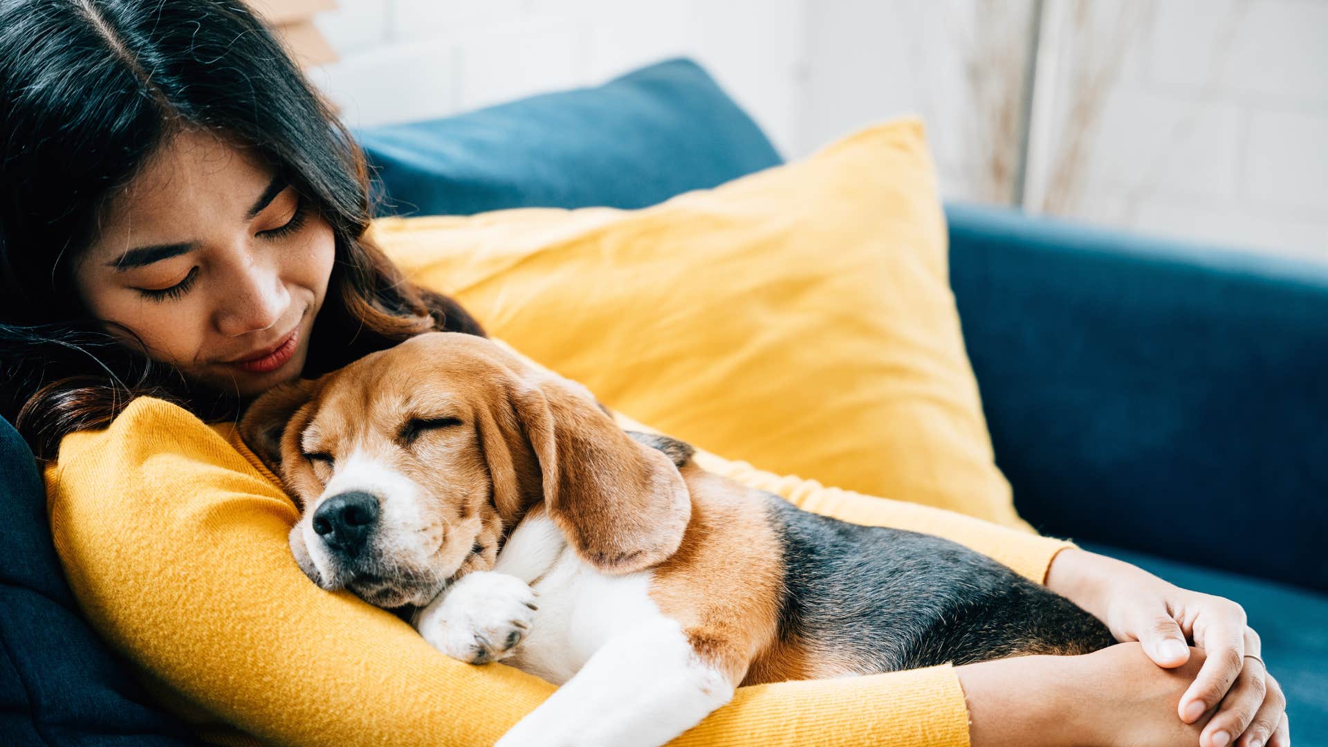 woman cuddling with sleeping dog