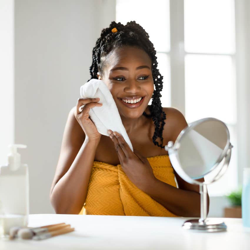 woman using a washcloth on her face 