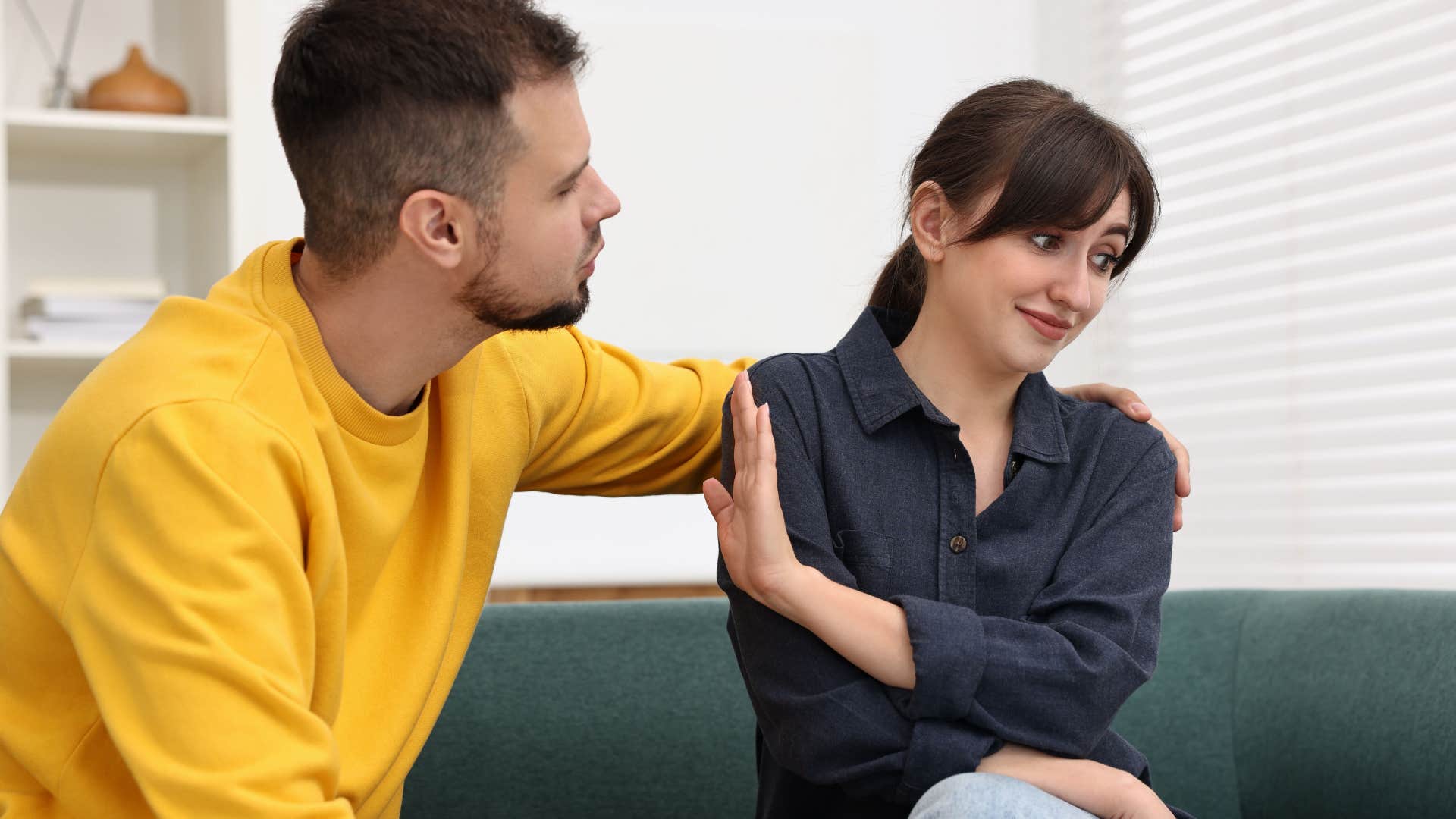 Woman quietly pushes man away showing not to ignore incompatibility