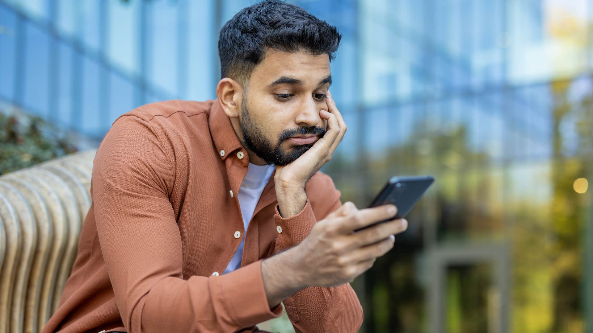 gen z man scrolling on his phone instead of reading