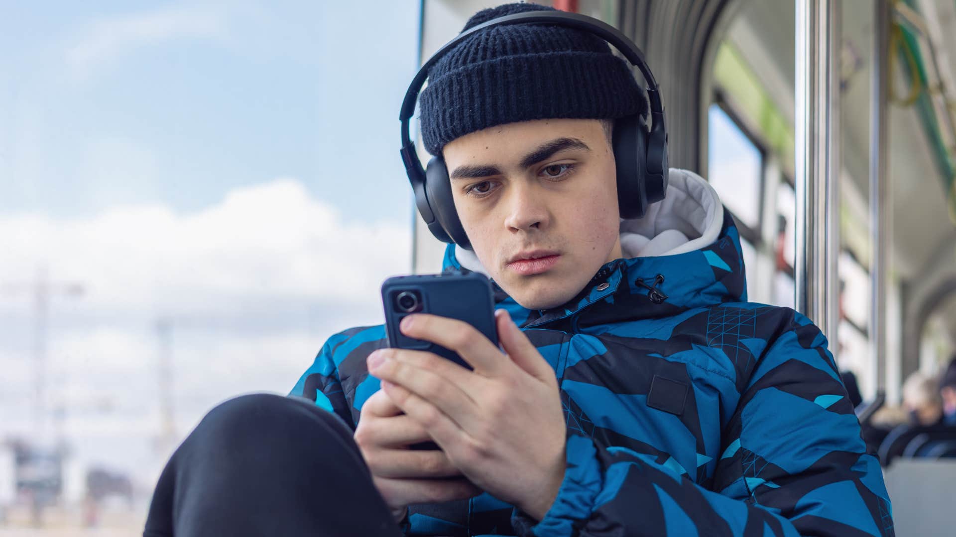 Gen Z man overusing screen time on the bus
