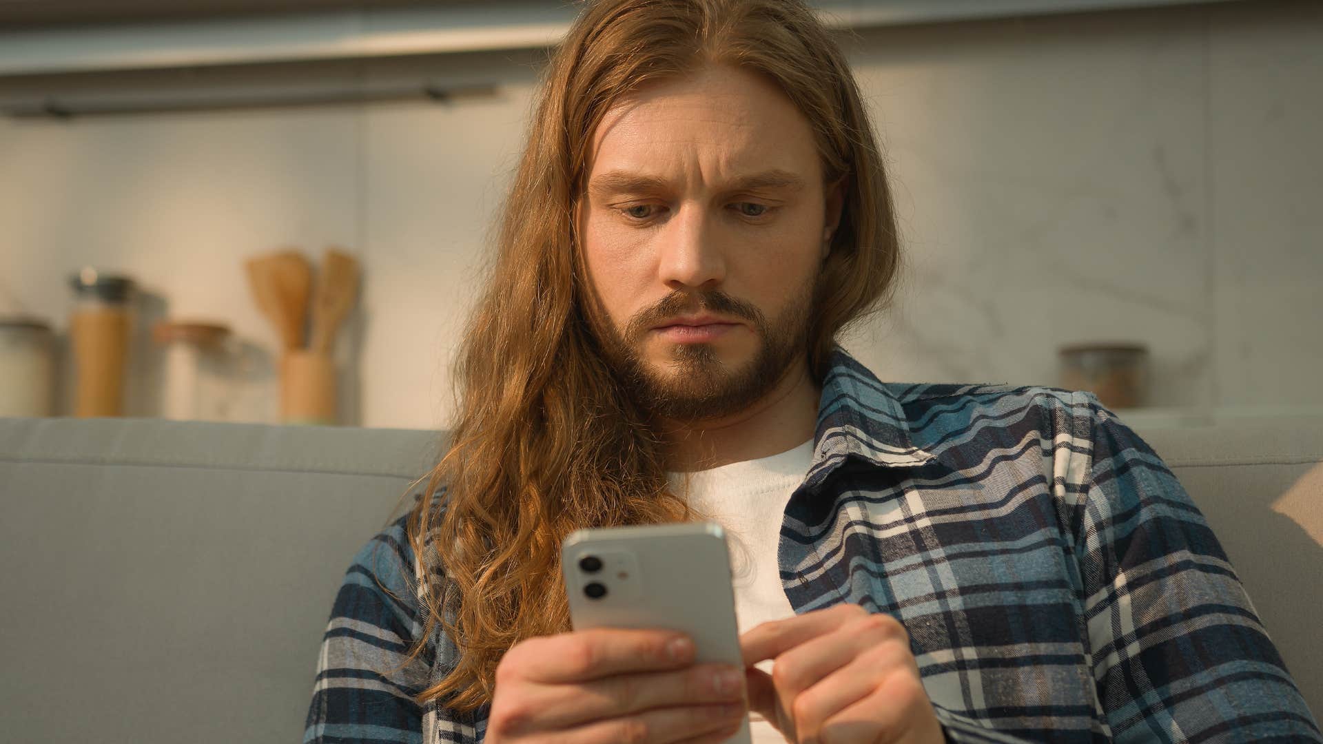 man on his phone feeling pressured to compare himself