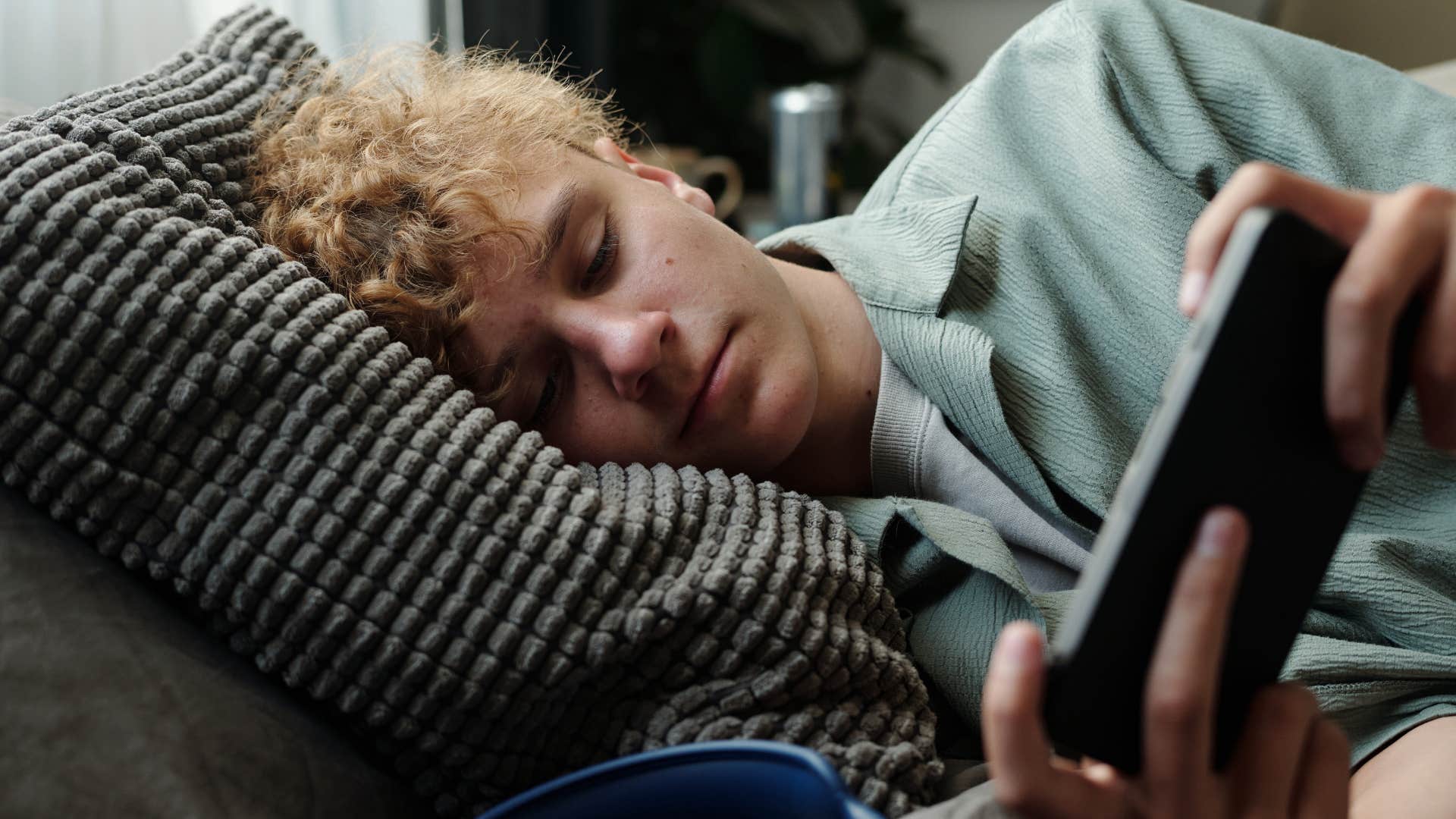 Gen Z man using his phone in bed
