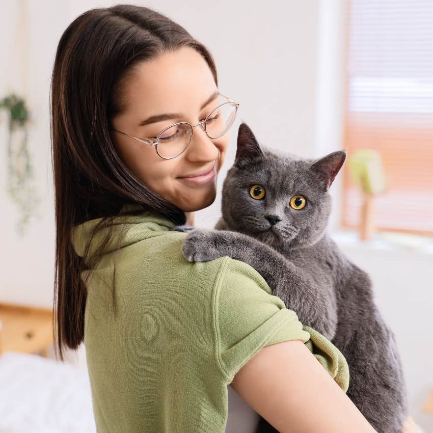 woman holding purring cat to relieve stress