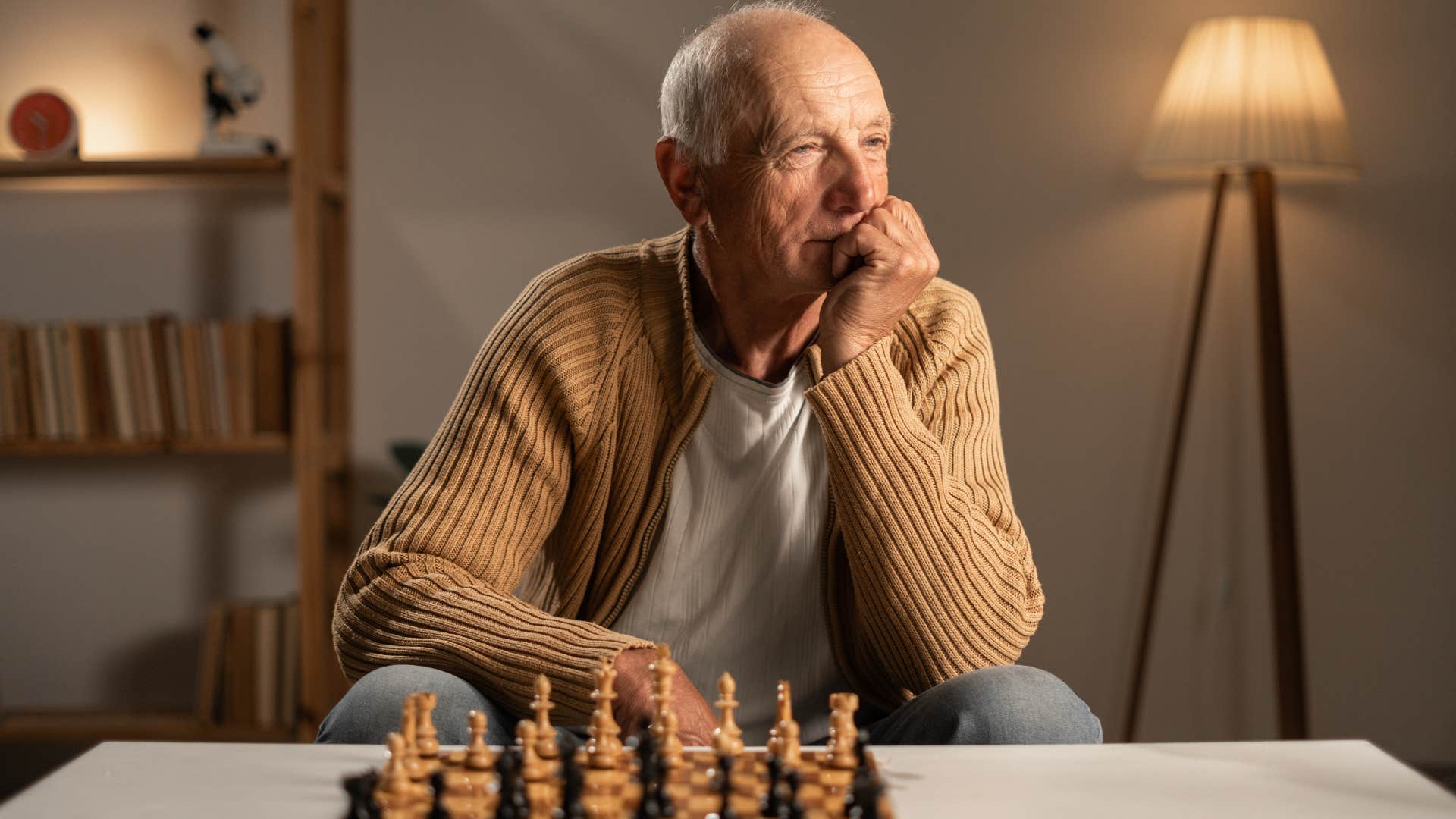 older man playing chess while thinking about his health habits