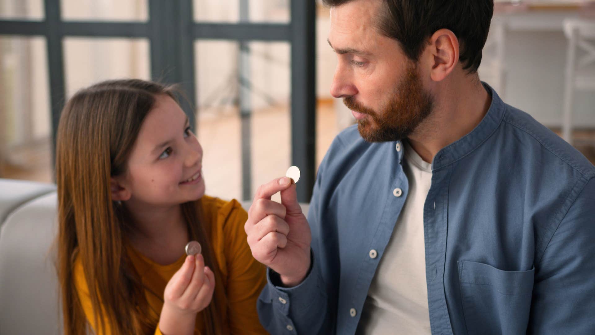 little girl learning financial literacy from her dad