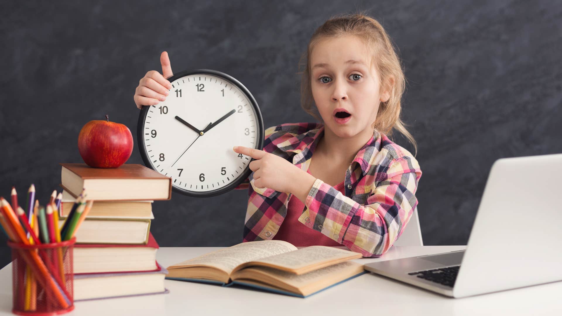 little girl reading an analog clock at school