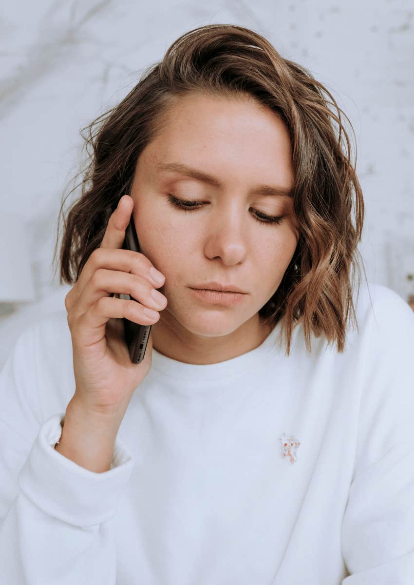 serious young woman receiving bad news in phone call