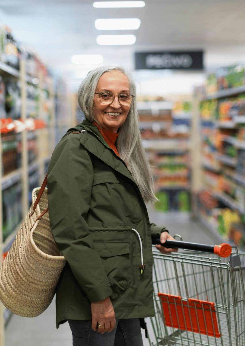 smiling older woman grocery shopping