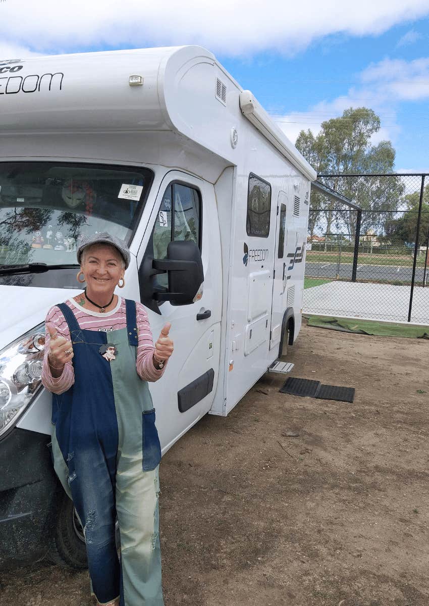 smiling older woman posing in front of an rv