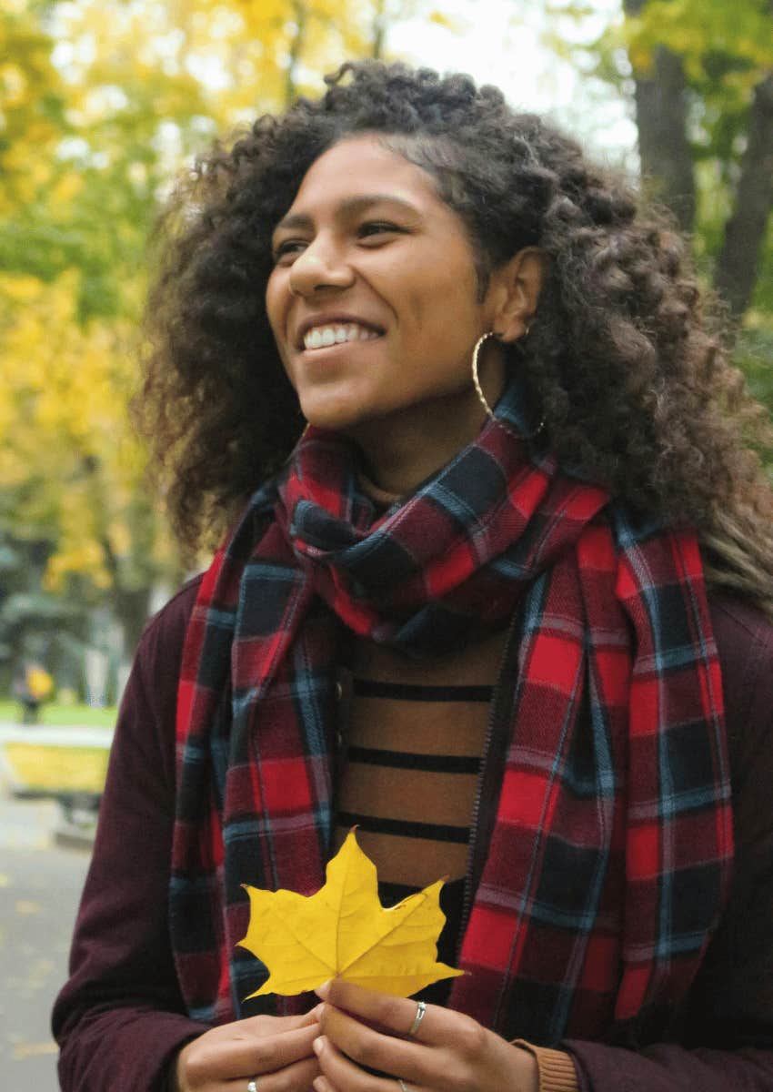 grateful smiling young woman holding a leaf