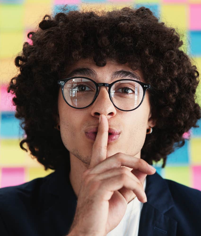 Person puts finger to lips showing discretion is rare skill