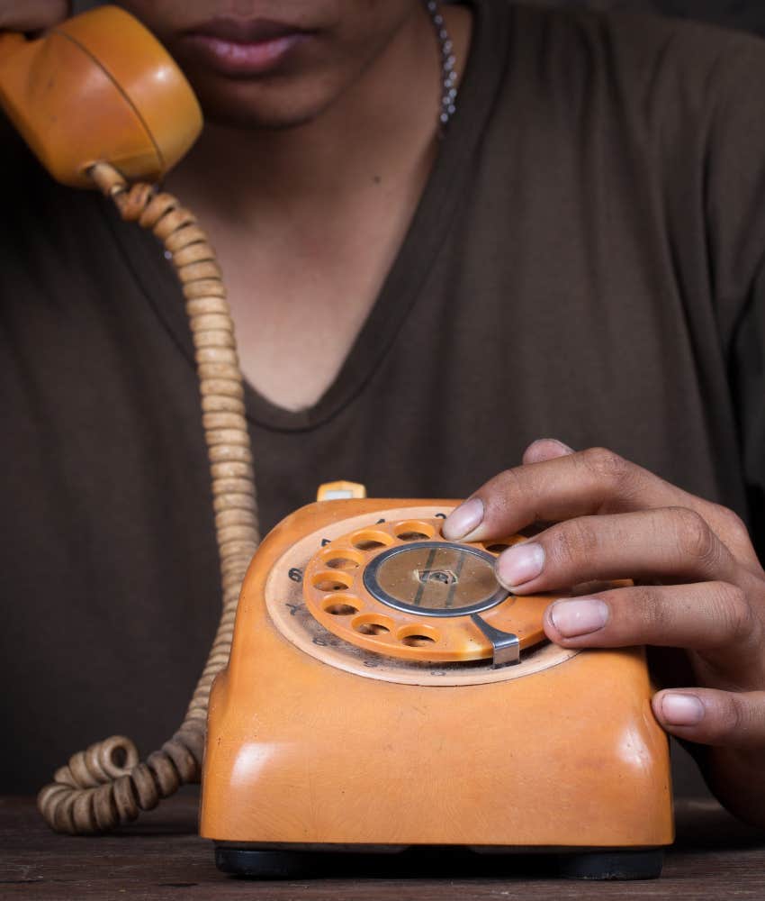 person dials number on old rotary style phone showing rare skill