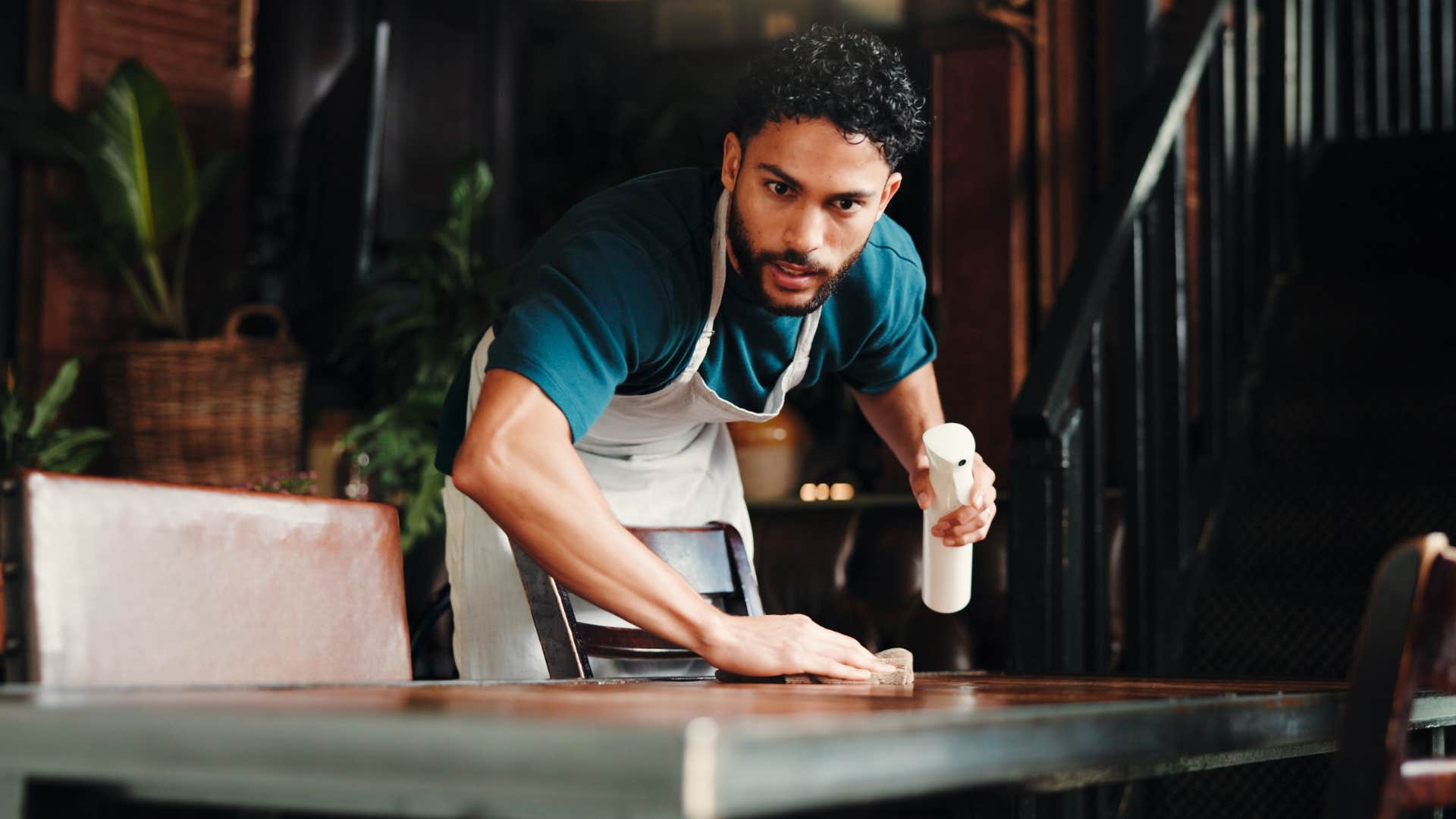 man wiping down table as he hates minor clutter